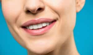אישה חייכנית עם שיניים בריאות לאחר טיפול שיניים